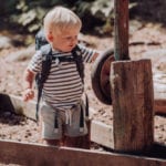 Junge spielt im Sandkasten mit Beckmann Kindergarten Rucksack Modell 2020 fire truck