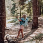 Mädchen klettert im Wald auf Seilen mit Beckmann Kindergarten Rucksack Modell 2020 Unicorn
